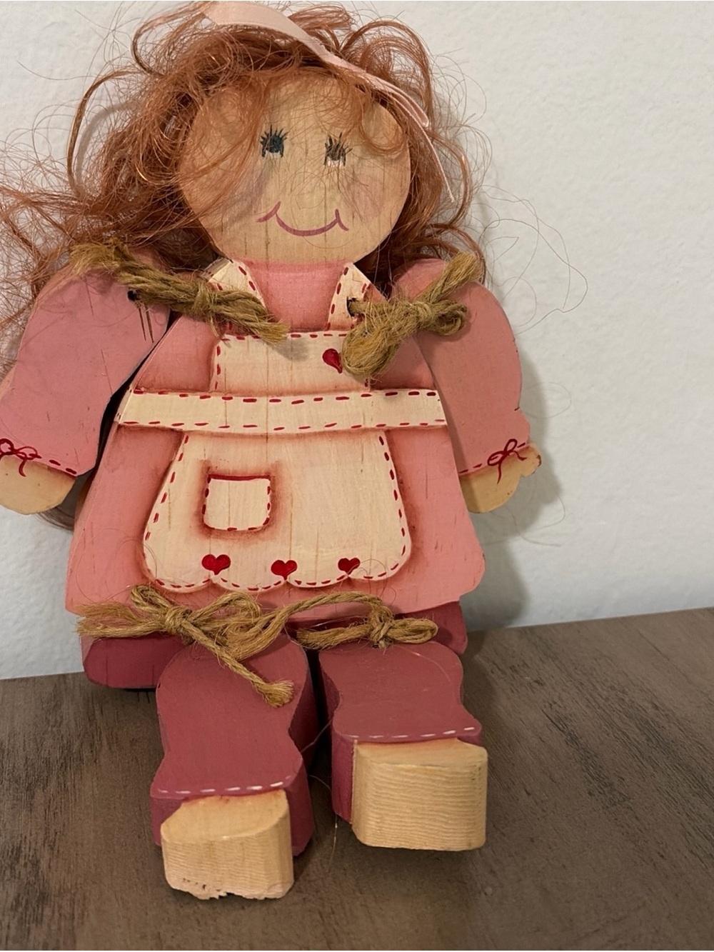 vintage handmade wooden folk art doll decorated in a pink dress
